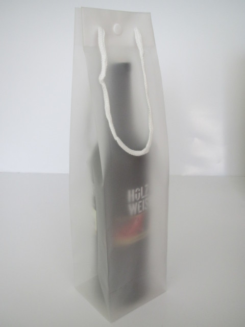 Flaschentaschen mit Druckknopf aus weiß transparenter Folie als Griffe wurden Kordeln eingesetzt